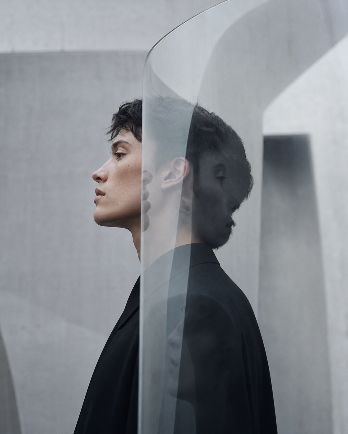 Androgynous model reflected through curved glass